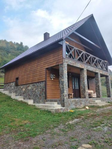 a large building with a roof on a field at Синевирський Краєвид in Synevyr