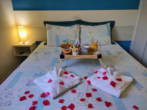 a bed with a tray of food and hearts on it at Pousada Marcos in Guarujá