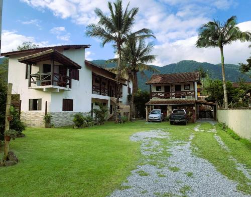 una casa con coches aparcados delante de ella en Suítes Maresias, en Maresias
