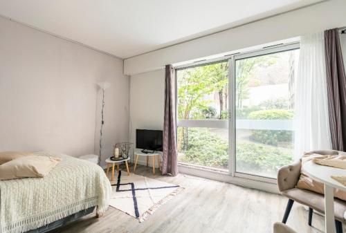 una camera con un letto e una grande finestra di Appartement Cosy Paris centre a Parigi