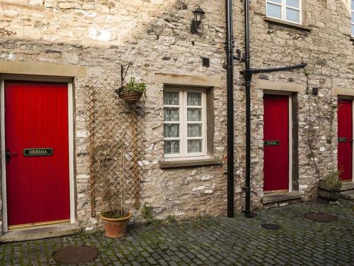 a stone building with red doors and a window at Shakespeare Inn in Kendal