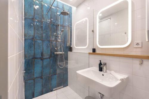 ein Bad mit einer Dusche, einem Waschbecken und einem Spiegel in der Unterkunft Cozy&Stylish at the Eastern Railway St. w Balcony in Budapest