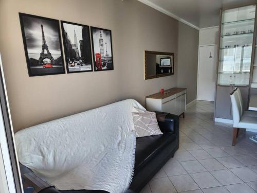 um quarto com uma cama e quadros na parede em Apartamento pe na areia e com vista linda em Florianópolis