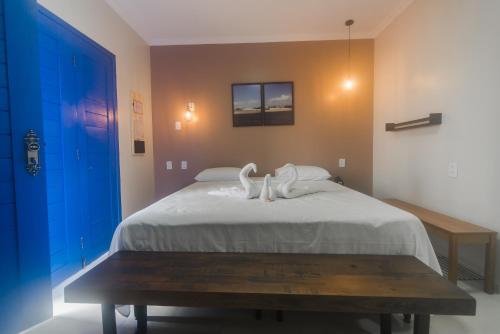 a bedroom with a bed with swans on it at Pousada Vila de Charme in Barreirinhas