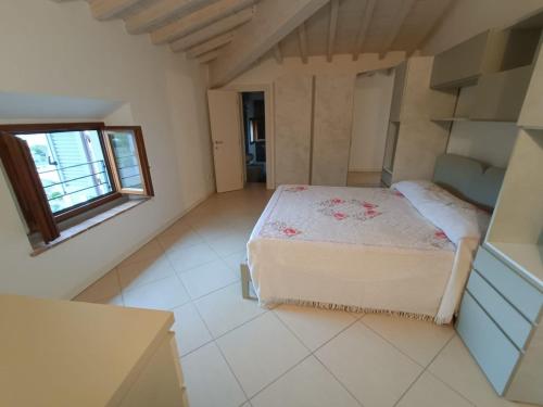 ein kleines Schlafzimmer mit einem Bett und einem Fenster in der Unterkunft Appartamento Vada in Vada
