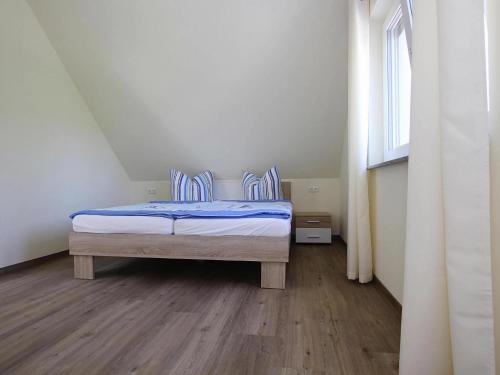 a bedroom with a bed with blue sheets and a window at Appartement Hafenflair am Plauer See in Plau am See