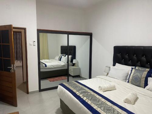 una camera con un grande letto e uno specchio di TD Guest House 8-Villa Sky a Chimoio