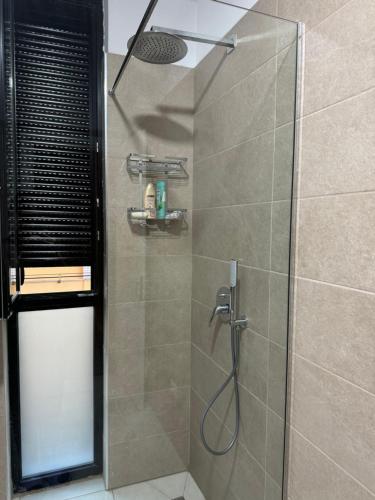 a bathroom with a shower with a glass door at SC Tirana Centre Apartment in Tirana