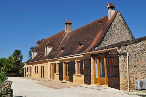 an old brick building with a brown roof at Gîte pour 4 personnes - Dordogne in Bressac
