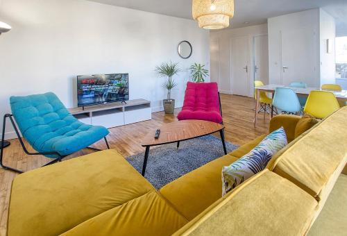 un soggiorno con divano giallo e sedie colorate. di L'Oasis Urbaine à Angoulême - Pro ou Groupe ad Angoulême