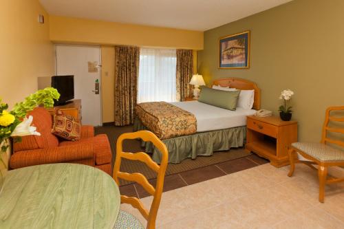 リノにあるLegacy Vacation Resorts - Renoのベッドと椅子付きのホテルルーム