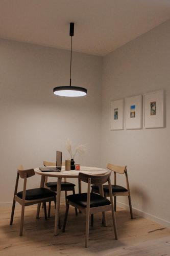 een eetkamer met een tafel en stoelen en een licht bij Albatross Club House 9 in Ķesterciems