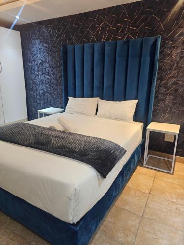 a bedroom with a large bed with a blue headboard at Yello Guest House Graskop in Graskop