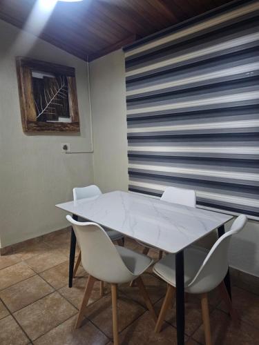 a dining room with a table and white chairs at Yello Guest House Graskop in Graskop