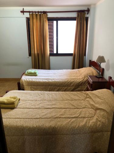 a hotel room with two beds and a window at Samaraña depto Jujuy in San Salvador de Jujuy