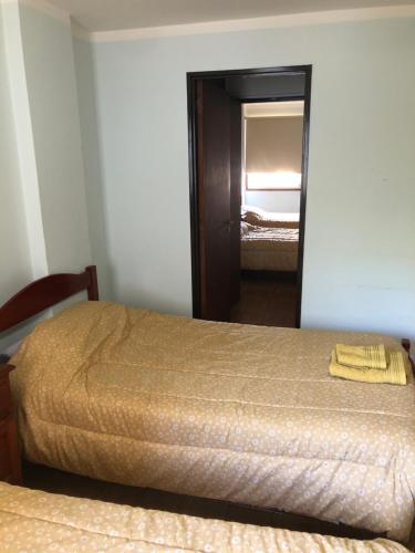 a bedroom with two beds and a mirror at Samaraña depto Jujuy in San Salvador de Jujuy