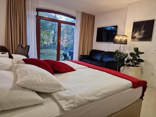 1 dormitorio con 1 cama grande con almohadas rojas y blancas en Aparthotel Gaja, en Bled