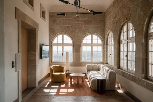 ein Wohnzimmer mit einem Sofa, Stühlen und Fenstern in der Unterkunft Zinar Castle in Krakau