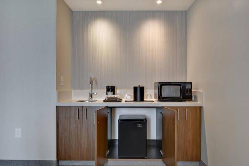 a kitchen with a counter with a sink and a microwave at Courtyard by Marriott Jackson Madison in Madison