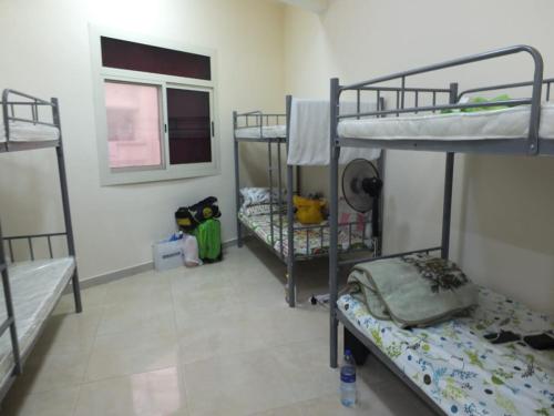 Zimmer mit 3 Etagenbetten und einem Fenster in der Unterkunft DUBEDZ in Dubai