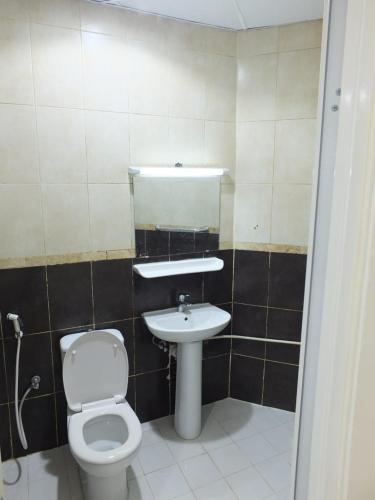 a bathroom with a white toilet and a sink at DUBEDZ in Dubai