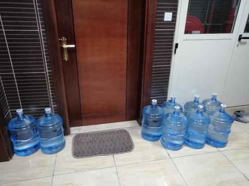 un grupo de botellas de agua azules sentadas frente a una puerta en DUBEDZ en Dubái