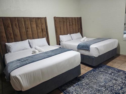 two beds in a hotel room with two beds at Yello Guest House Graskop in Graskop