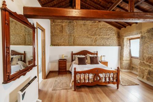 a bedroom with a bed and a large mirror at O Fogar do Carpinteiro in Carnota