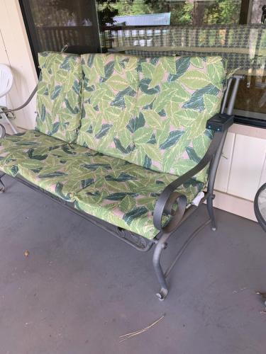a bench sitting on a porch with a green leafy couch at Mercury Villa - Room in Private Residence in Grass Valley