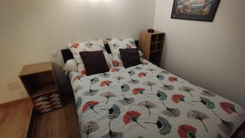a bed with a comforter on it in a bedroom at Gîte vacances Bosc d'esquirol 4 pers in Escorneboeuf