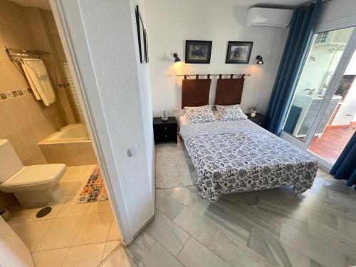 ミハス・コスタにあるJardines de Calahondaのベッドルーム1室(ベッド2台、シャワー、トイレ付)