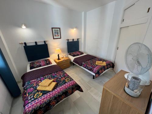 ミハス・コスタにあるJardines de Calahondaのファン付きの小さな部屋のベッド2台