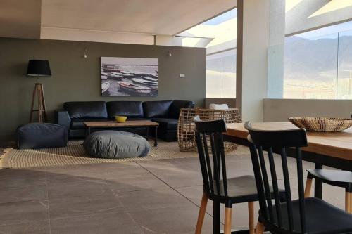 - un salon avec un canapé, une table et des chaises dans l'établissement Cómodo Dpto con Piscina a pasos de Mall La Portada, à Antofagasta