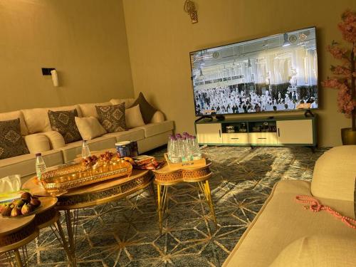 a living room with a couch and a flat screen tv at Relaxing Alula in Al-ʿUla