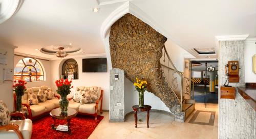 sala de estar con sofá y pared de piedra en Hotel Fontibon en Bogotá