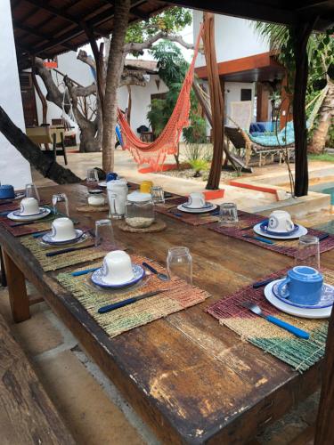 einem Holztisch mit Tellern und Geschirr darauf in der Unterkunft Villa Cajuiero Inn in Prea