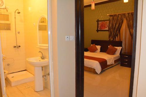 1 dormitorio con 1 cama y baño con lavamanos en العيرى للشقق المخدومه جيزان 3, en Jazan