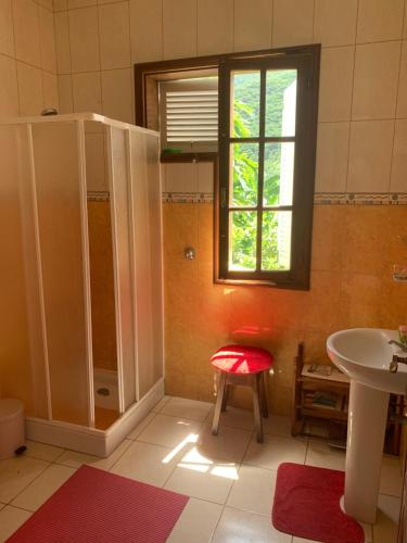 uma casa de banho com um chuveiro e um banco vermelho em Wahnon Guesthouse em Paul