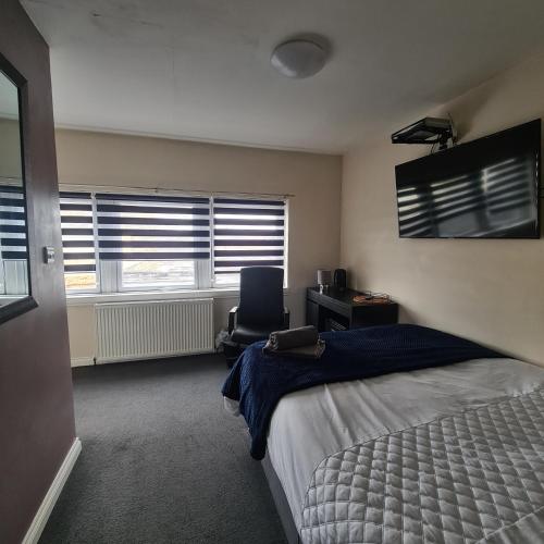 - une chambre avec un lit, un bureau et une chaise dans l'établissement The Beath Inn, à Cowdenbeath