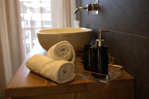 a bathroom with a sink and towels on a table at 4Seasons appartamenti in Sauze dʼOulx
