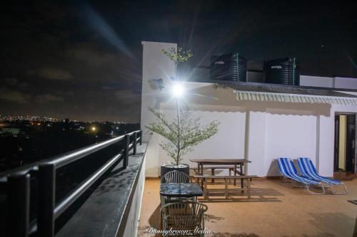 a rooftop patio at night with a table and chairs at Executive Two Bedroom Apartment in Accra in Accra