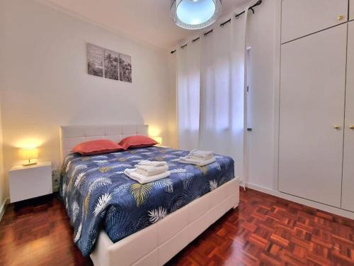 a bedroom with a bed with towels on it at Junto ao Mar - Apartamento T1 in Santa Cruz