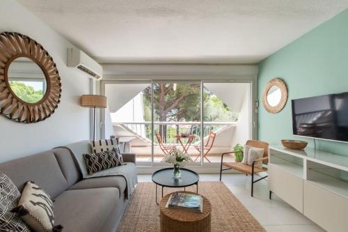 un salon avec un canapé et une table dans l'établissement Au fil de l'eau * studio canapé lit confortable * clim réversible * cosy * Élégant, à La Grande Motte