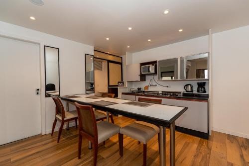 a kitchen with a dining room table and chairs at Metropolitan Flats in Curitiba