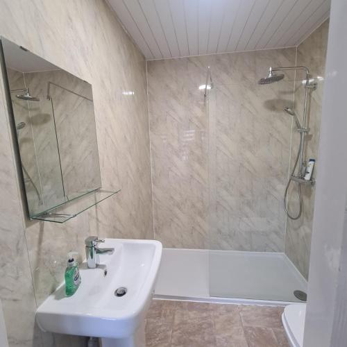 a bathroom with a sink and a shower and a tub at The Beath Inn in Cowdenbeath