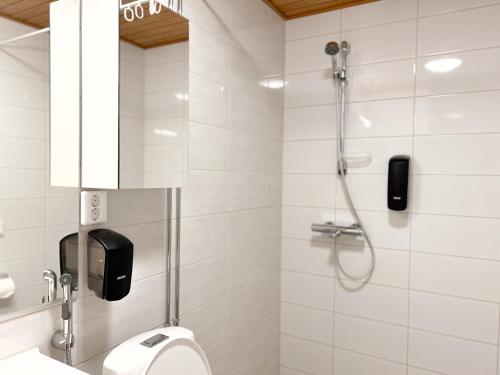 a white bathroom with a shower and a toilet at Rollo Apartments in Rovaniemi