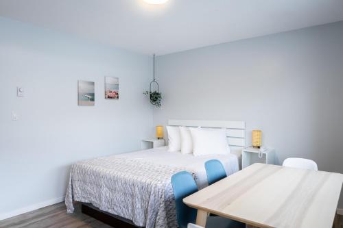 a bedroom with a bed and a table at Poplars Motel on the lake in Osoyoos