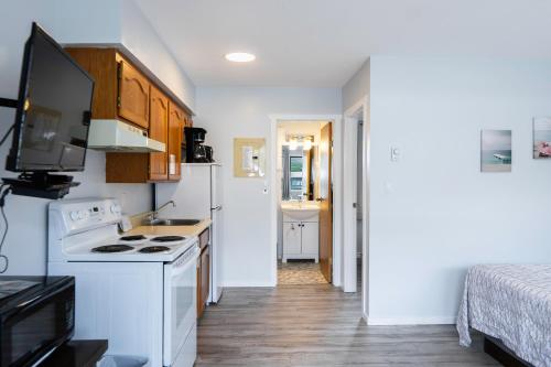 a small kitchen with a stove and a sink at Poplars Motel on the lake in Osoyoos