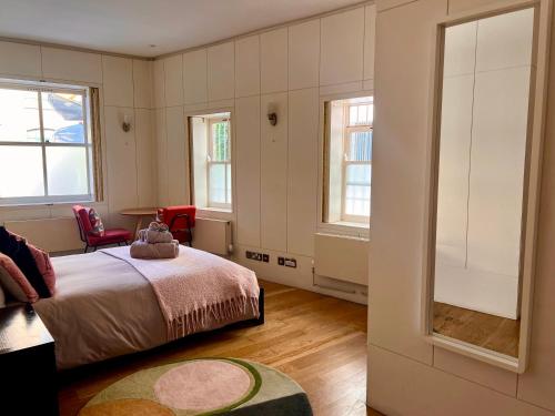 a bedroom with a bed and two windows at Shoreditch Private Studio in London
