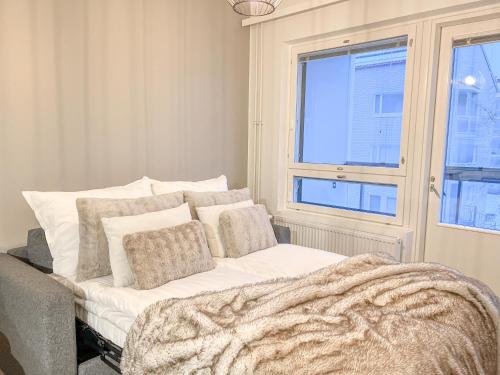 a bedroom with a bed with a blanket and a window at Rollo Apartments in Rovaniemi
